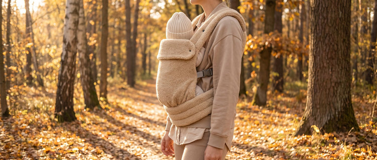 Ouder wandelt met baby in de Laavir teddy-draagzak door het park
