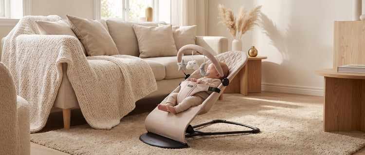 Baby in de beige Laavir wipstoel in de woonkamer